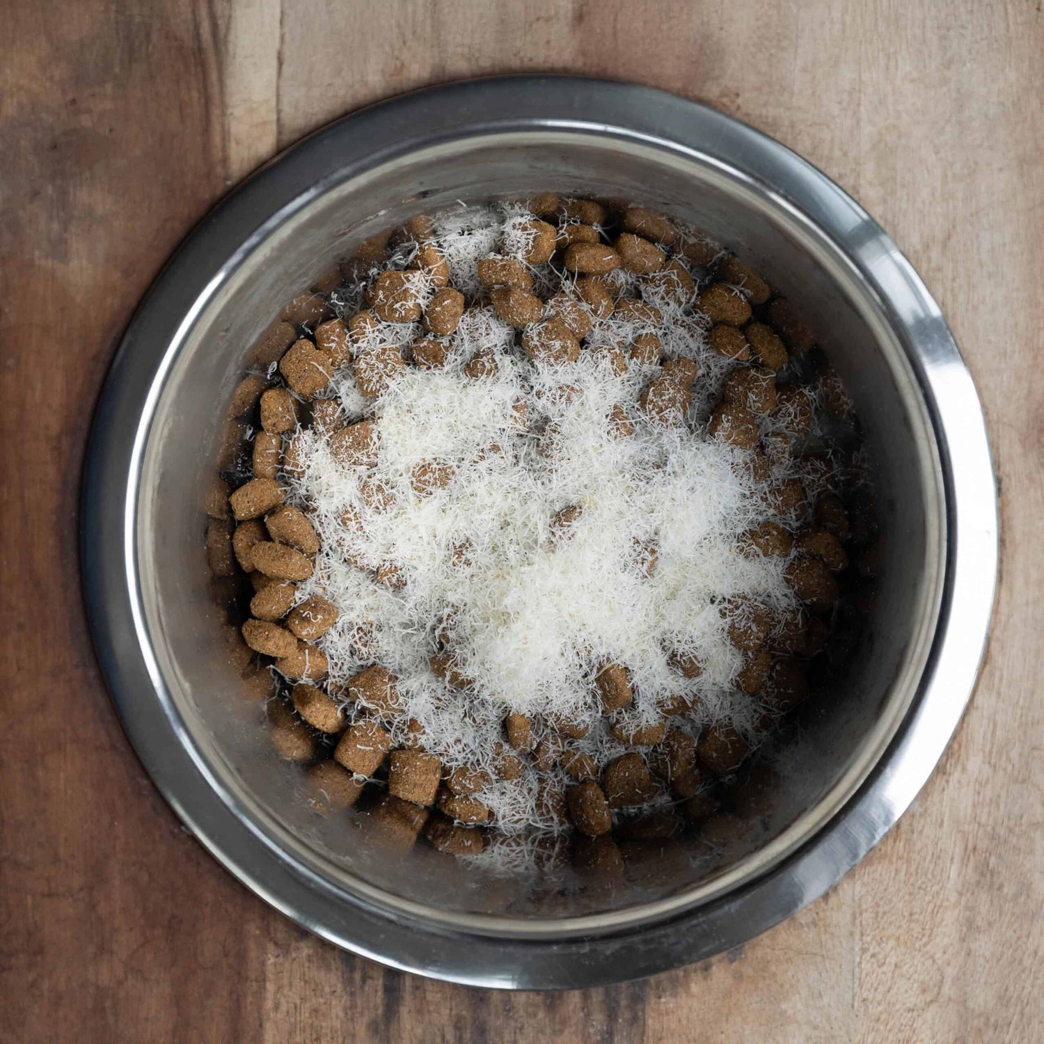 Parma Yak natural grated yak cheese sprinkled on dog food in stainless steel bowl